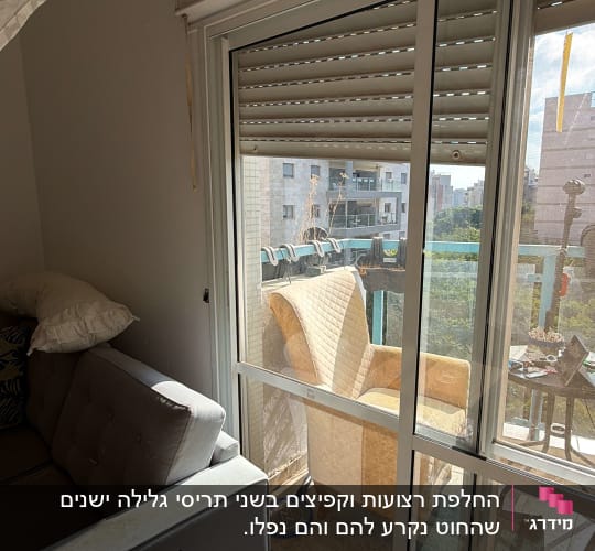 חלון זכוכית עם תריסים וספה לידו
